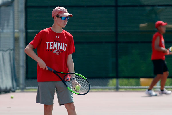 Noah Batson, 10, gets ready to serve during tennis practice. 