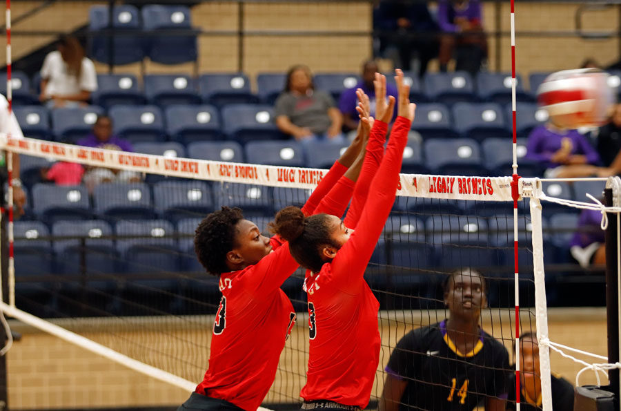 Maylasia Murdock, 12, and Keslyn King, 12, jumps into the air and block the ball