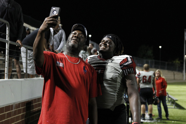 Taurean Carter, 12, takes a picture with his uncle after Legacy won against Timberview, 27-22. (Kristen Bosecker photo)