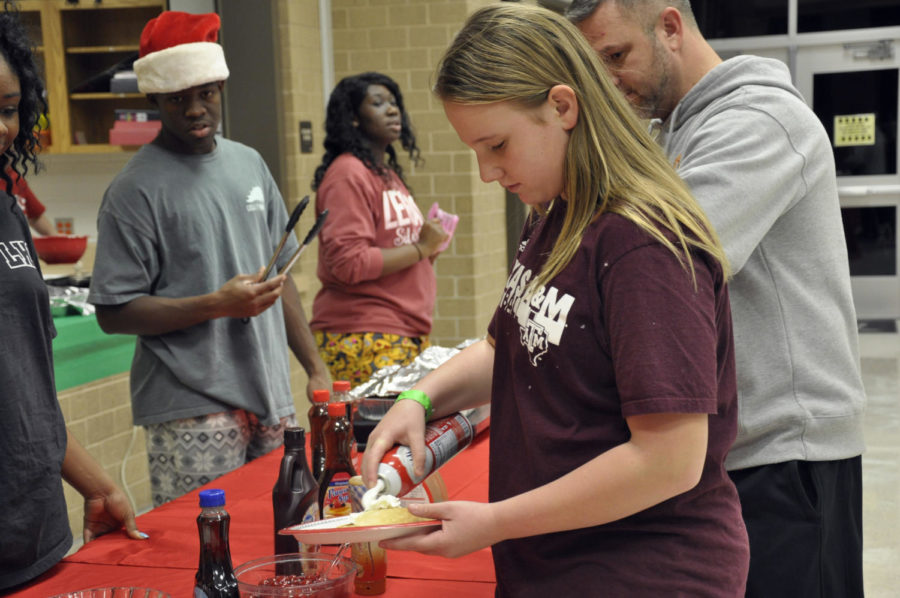 Students put toppings on their pancakes at the Holiday Hoopla on Dec. 1. After the all-you-can eat pancakes, participants watched Elf. 
