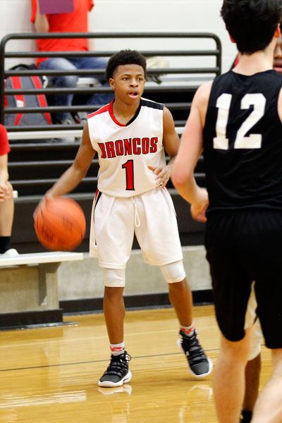 RJ Hopes, 9, runs time on the clock during the basketball game against Burleson High School.  (Madison Gonzales photo)