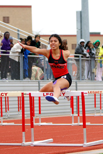 Anna Pacheco, 10, jumps over the hurdle in the JV girls 100 m hurdle race. (Kassidy Duncan photo)