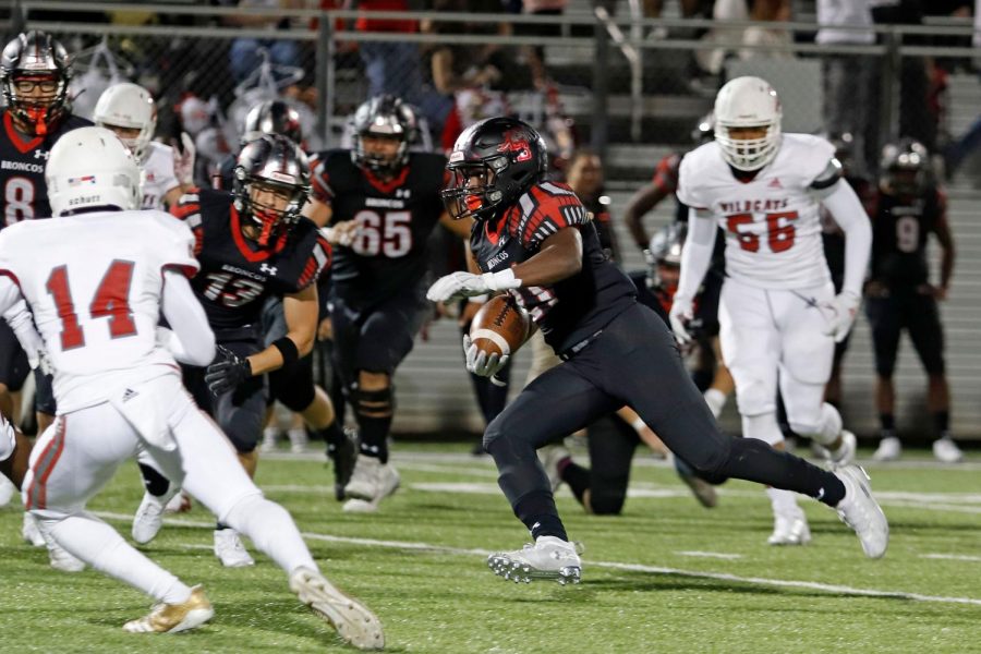 Senior Ayo Adeyi runs with the ball during the homecoming football game. The team defeated Dallas Woodrow Wilson 34-7.