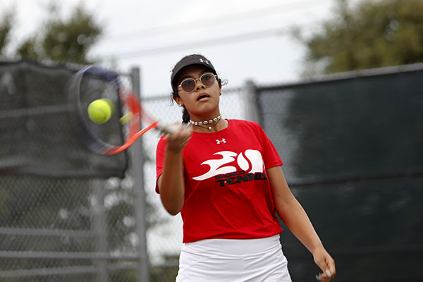 Liberty Ramos, 10, hits a forehand at the district match against Burleson High School.