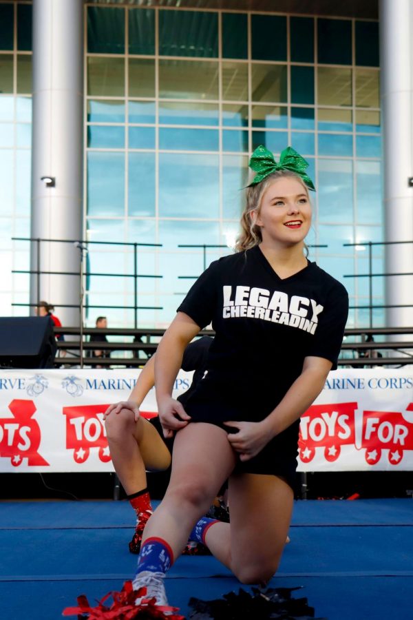 Emma Rogers, 11, warms up before the varsity cheer performance at Toys for Tots. (Conner Riley photo)