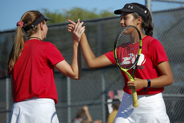 Mia Retnam, 12, gives a high five to Abby Carpenter, 11, during a fall match. The team hopes to capitalize on their success from the fall in the upcoming spring season. 