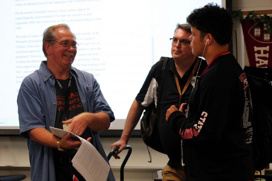 Debate sponsor Howard Ritz explains a case file to a student during practice. 