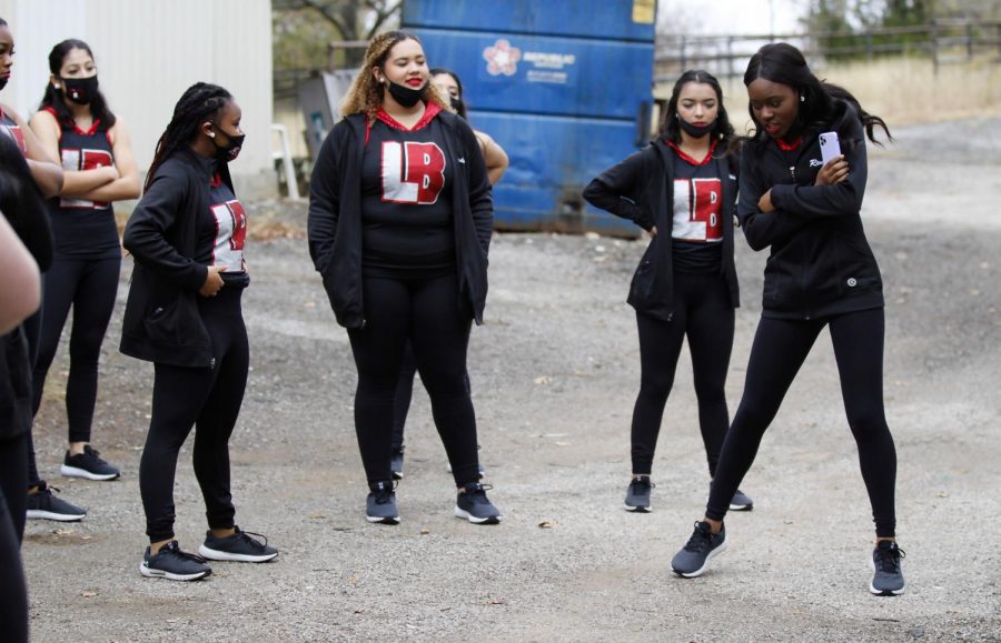 Renee Ajibola, 12, goes over the steps for next routine with the other dancers behind the main dance space.