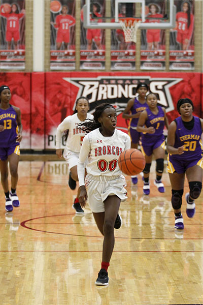 Dribbling across the court, Coniah Cooley, 12, makes her way to the basket at the varsity girls game against Everman on Jan. 19. The varsity team played 13 district games. (Madison Gonzales Photo)
