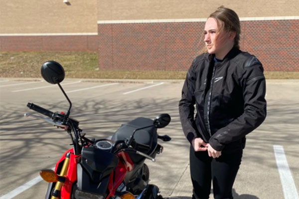 In the school parking lot, sophomore Della Duke prepares to ride her motorcycle home.