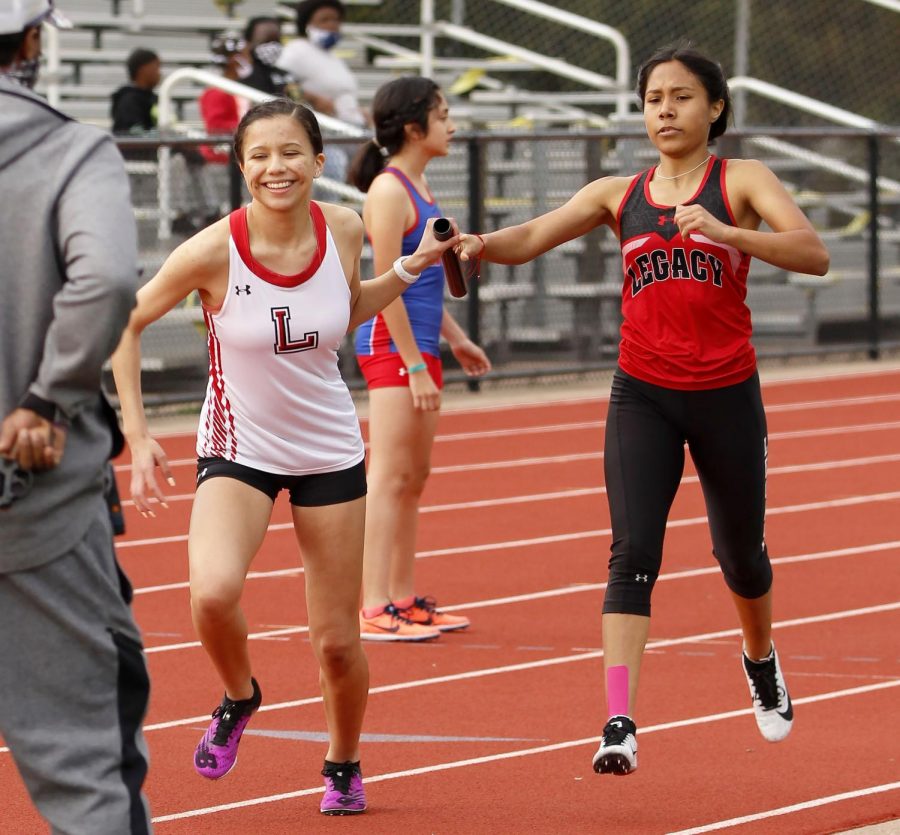 Sophomore Ariana Pacheco passes the baton to Leilani Fierro. (Madison Moyer Photo)