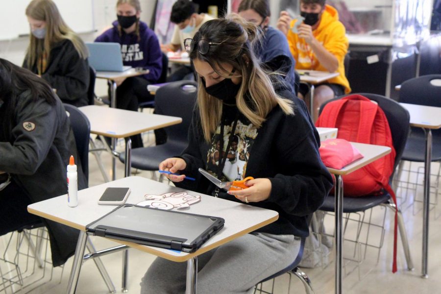 Leslie Mendoza, 12, designs her paper doll in her classroom with all properly masked students.