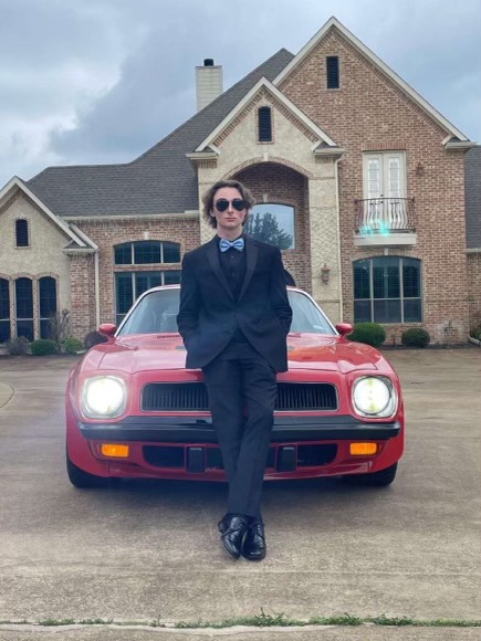 Senior Jay Smith stands in front of his car for a photo