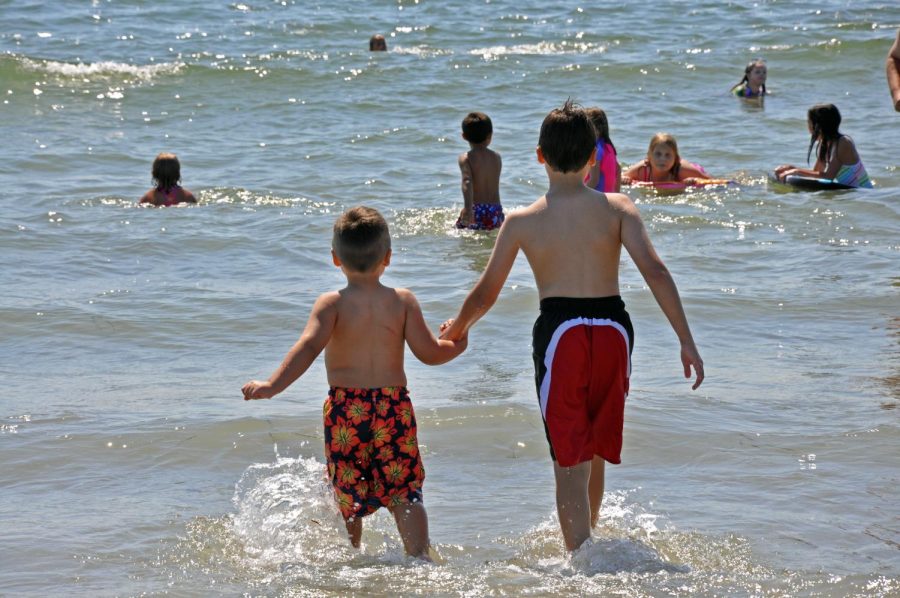 The Pedroza brothers walk into the ocean on family vacation to the Captain Roger Wheeler Beach in Rhode Island. 