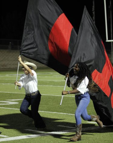 JROTC members run across the field with the Bronco flags at Mansfield vs. Legacys Football game.
