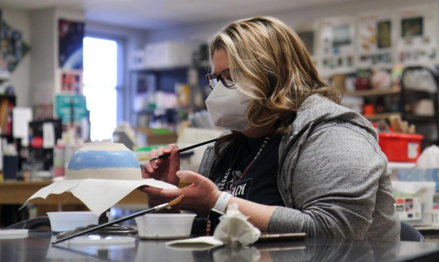 Ms. Pamela Pinkerton, librarian, paints a bowl for the Souper Bowl on Feb. 11.