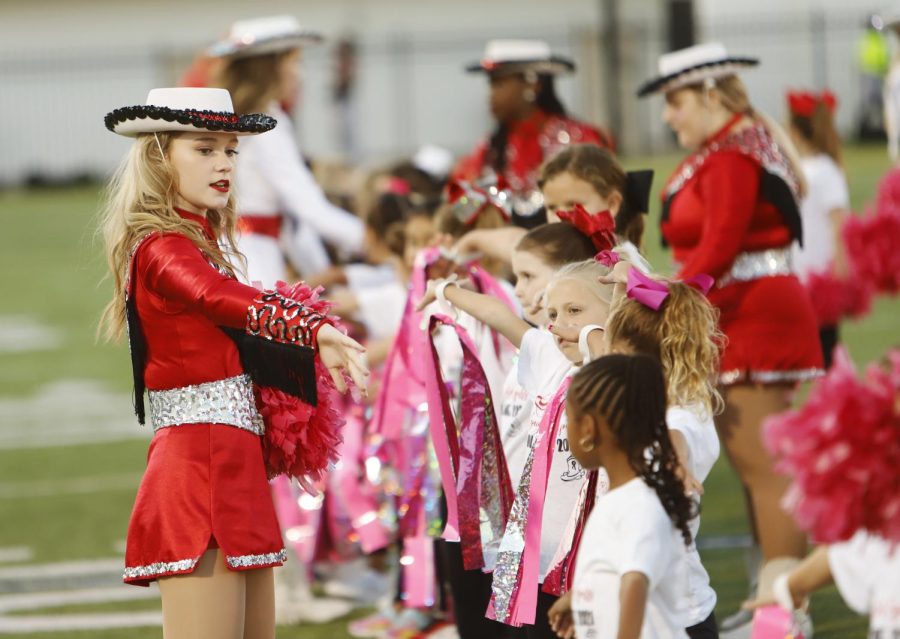 Sophomore Kadence Whitfill instructs the girls to hold their ribbons as they wait on the sidelines to perform at the football game on Oct. 15.