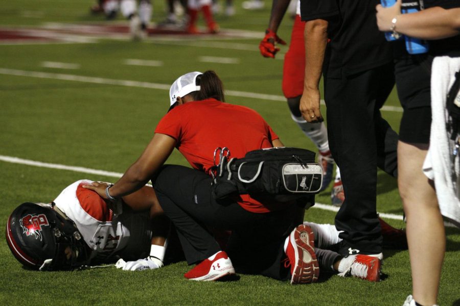 Legacy lost to Eaton High School 47-0 on Sept. 2. Trainer Kassey Newton treated a player on the sideline.