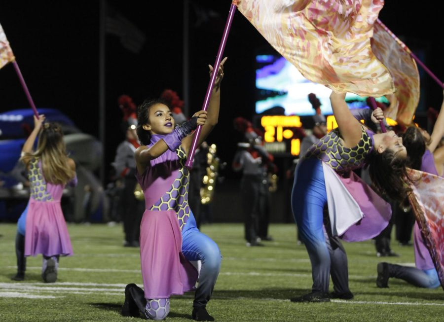 Members of the color guard compete with the band and preform during the halftime show at varsity football games.