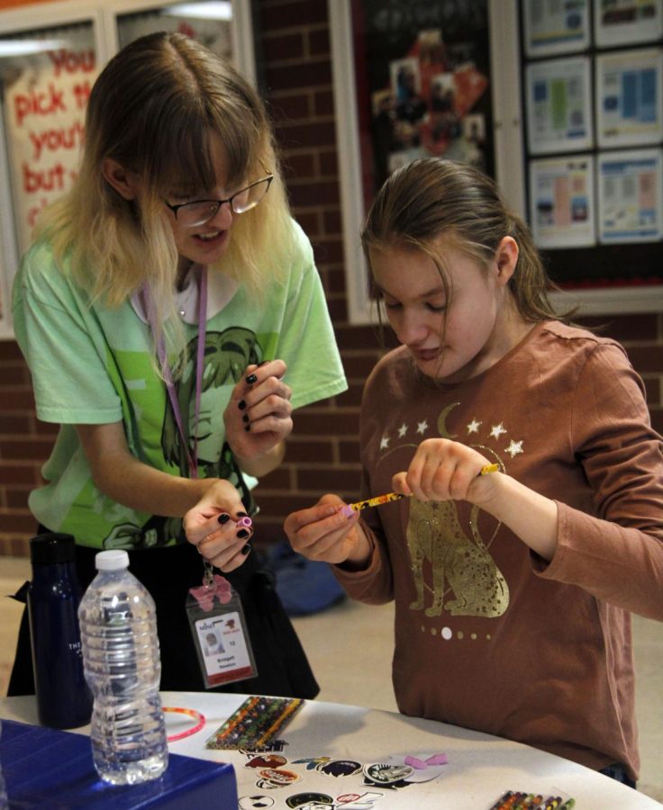 Bridgett Newton, 12, works with a FALS student at the AQR Carnival on Oct. 25. AQR students hosted the carnival to demonstrate real life probability in games.