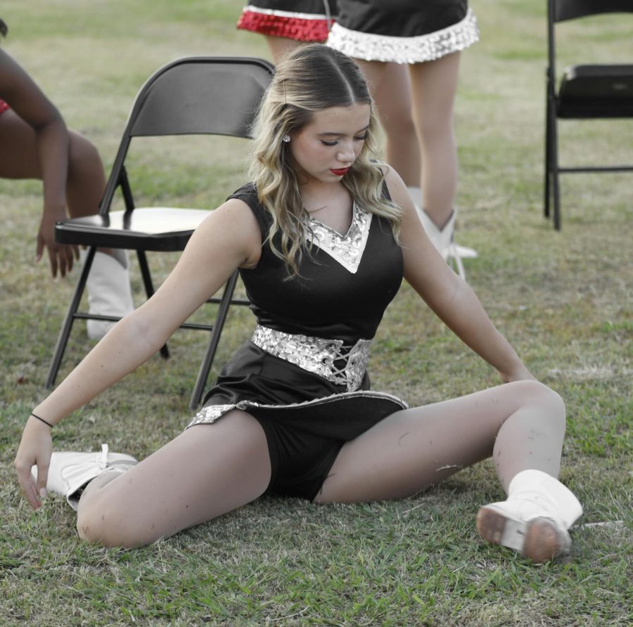Varsity Silver Spur and JV Officer, Taylor Menting, 11, stretches before half time where they perform.(Caelin Cox Photo)