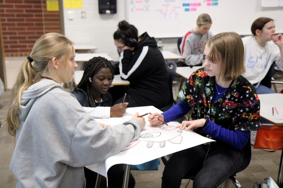 Juniors Emma Johnson, Judy Johnston and Joy Atkens, 10, work on a poster during advisory on Dec. 14, 2022 for Hope Squad. 