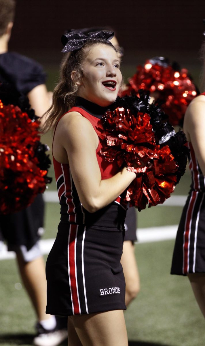 Sophomore Kennedy Milam cheers during the blackout game against Mansfield Sept. 15.