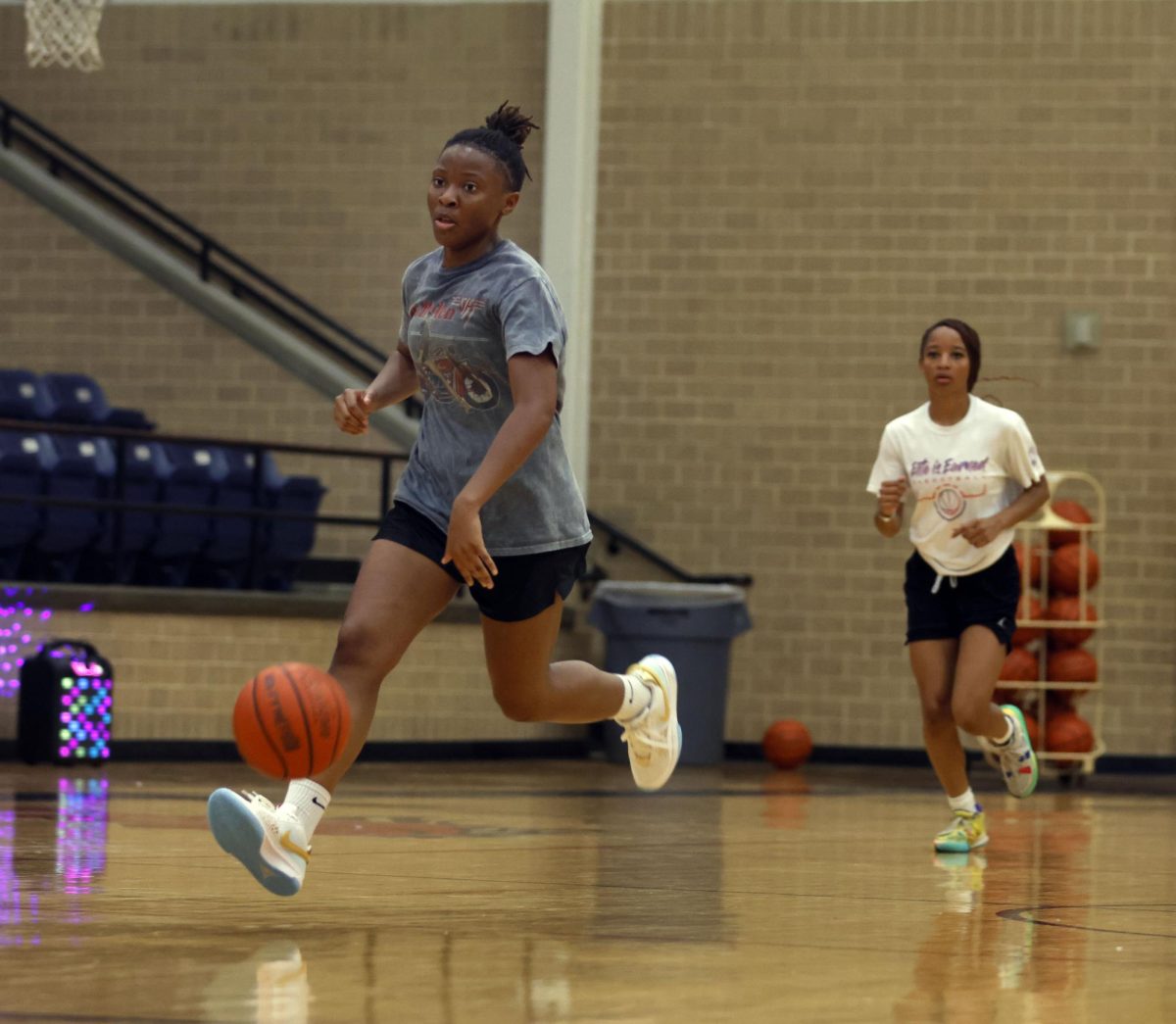2024 graduate Jasmine Jenkins dribbles the ball down the court during summer basketball practice with other team members.