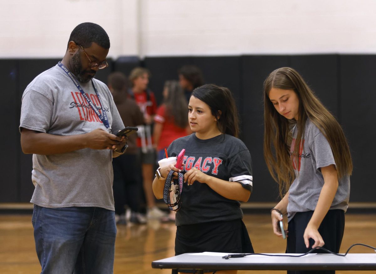 London Laurence, 12, discusses the plan for Freshman Roundup with teachers Dedric Williams and Alyssa Estrada. Freshman Roundup was held on Aug. 1.