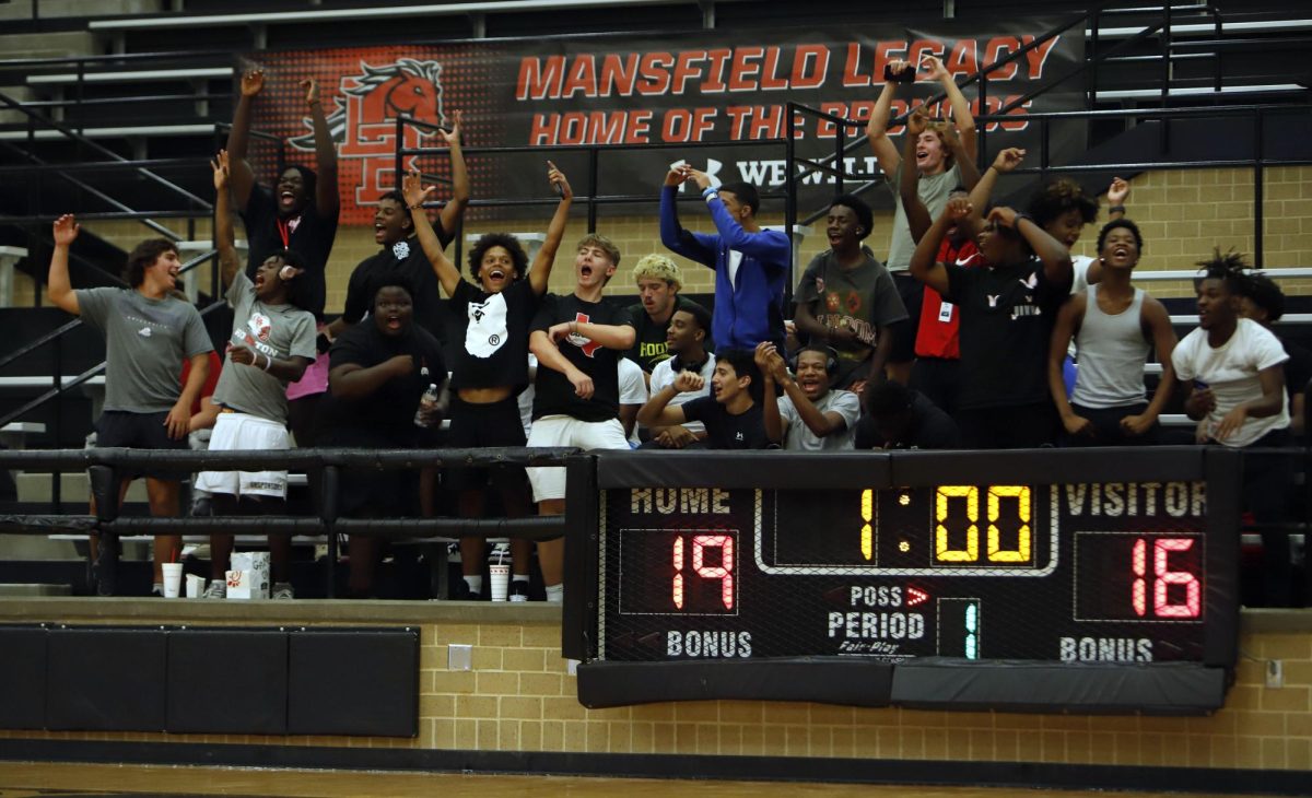 At the varisty volleyball game against Arlington Lamar on Aug. 20, football players cheer on the team. Legacy beat Lamar.