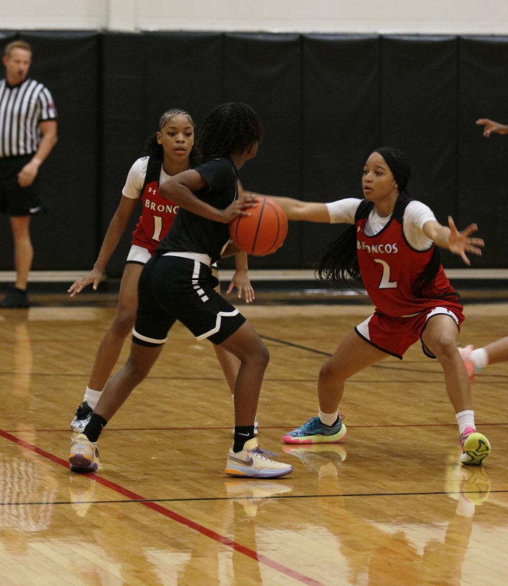 In the first varsity girls' basketball game, Cy'Nia Jackson, 10, and Madison Crawford, 11, trap a girl while playing defense. This led to a win.