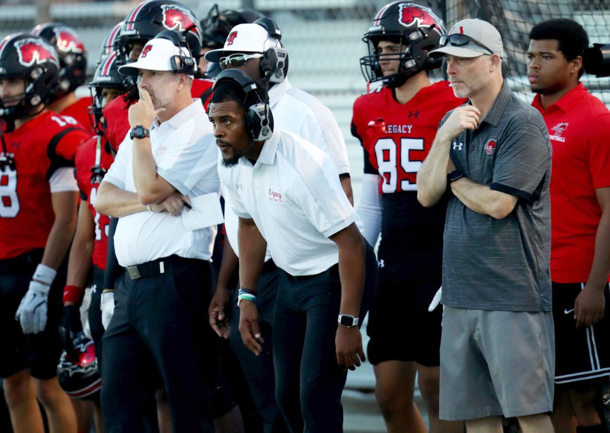 Football coaches Kendall Catalon, Benjamin Lackey and Aaron Thomas use new video replay system to review game against Justin Northwest on Aug. 30.