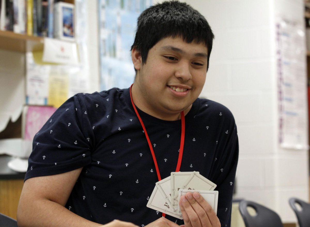 At after-school gaming club, Michael Perez, 11, waits for his turn as he and club members play “Here to Slay.” The gaming club is where different sorts of games are played with other students.