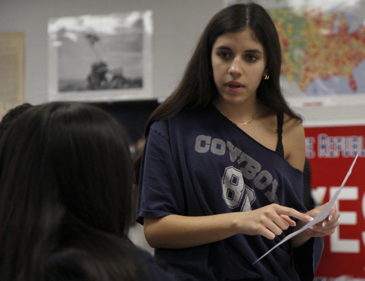 At the National History Club, Vivienne Kerley, 10, aids another student and discusses the World History Socratic seminar. The National History Club is a club where students can join and receive student help on certain historical topics and assignments.