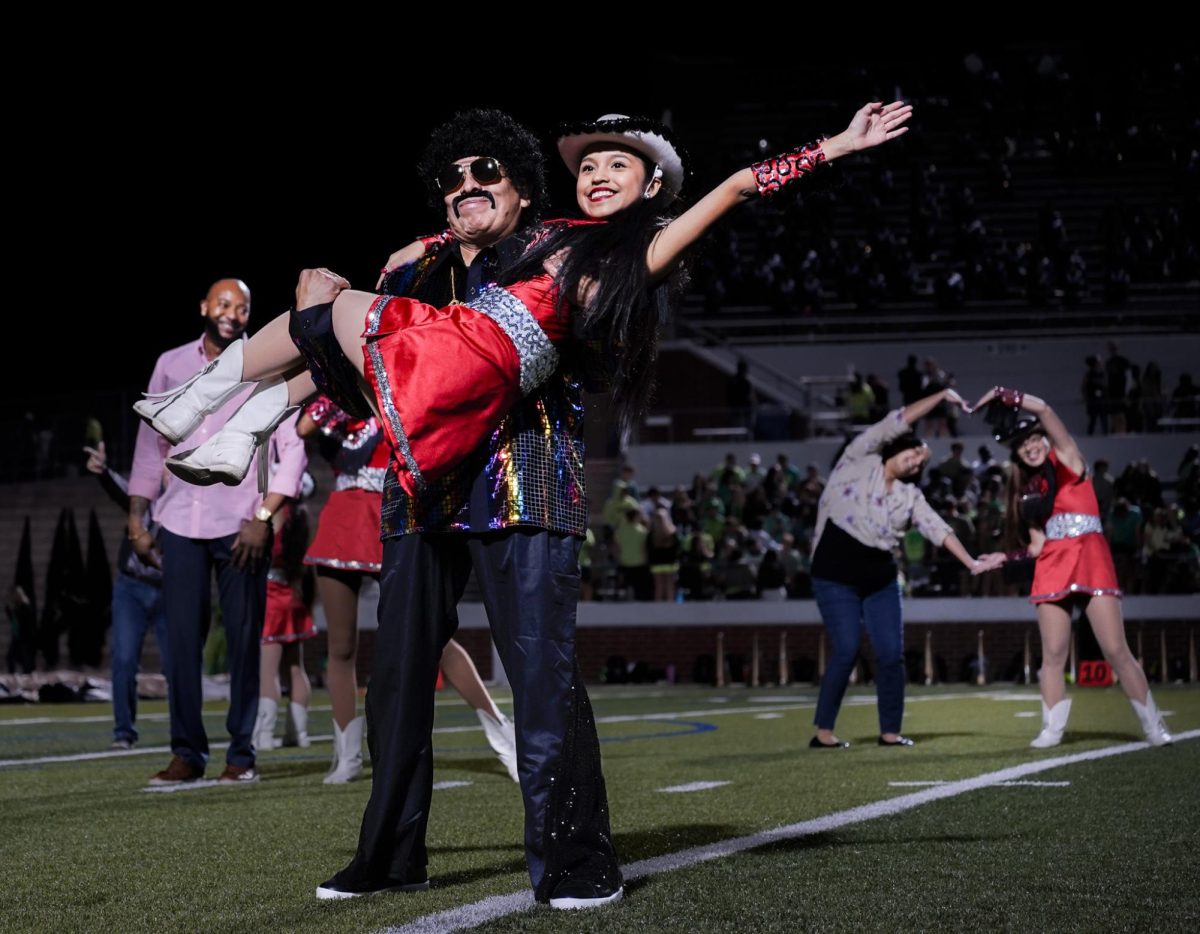 During the pink out game at half time Autumn Capetillo, 10, dances with her Dad. Silver Spurs dance their traditional “Bob and Sue” every senior night. 