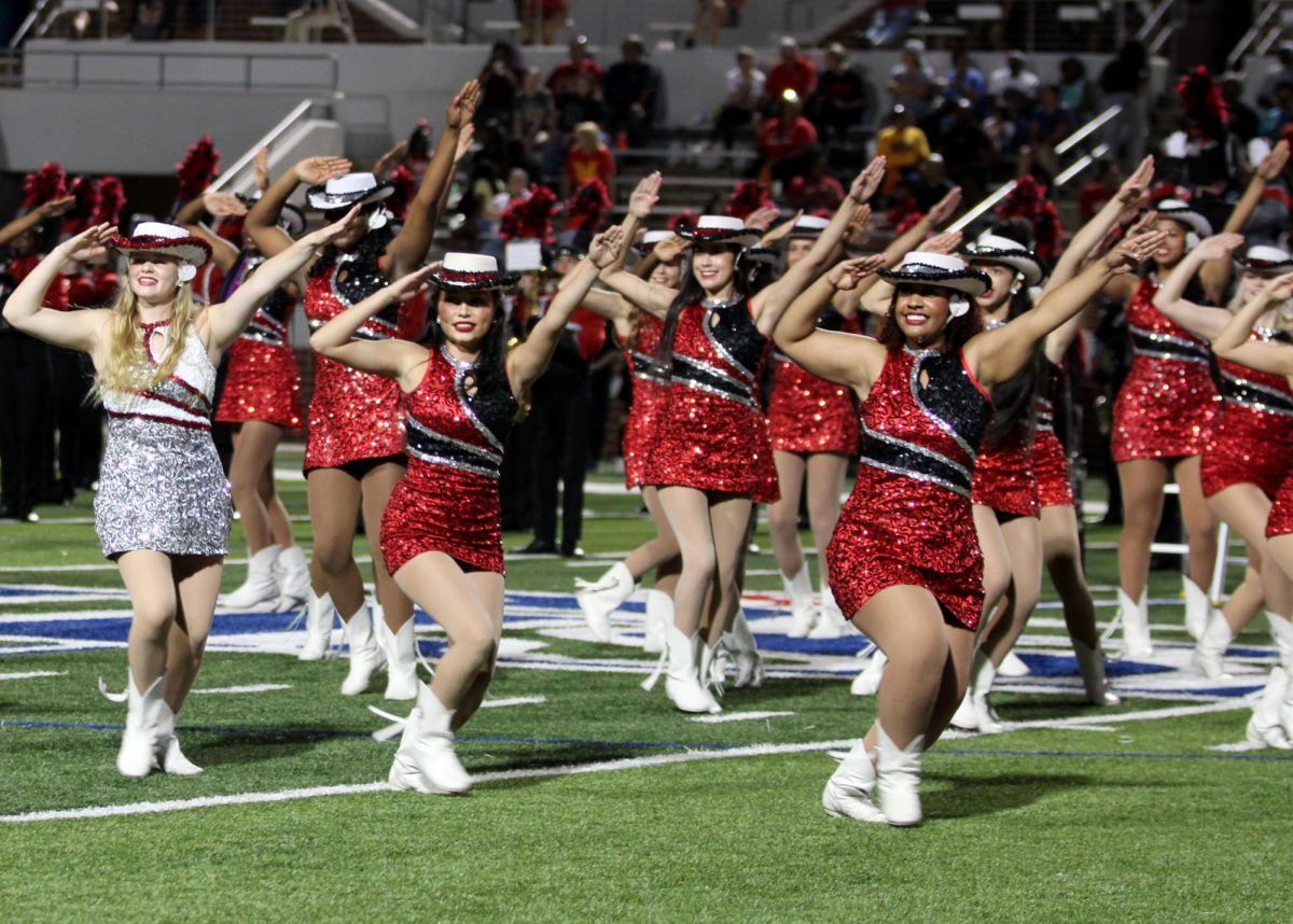 During the halftime performance, Emma Beaudine, 11, Kaitlin Helen, 12, and Kailey Trevino, 12, lead the Silver Spurs at the game against South Grand Prairie.