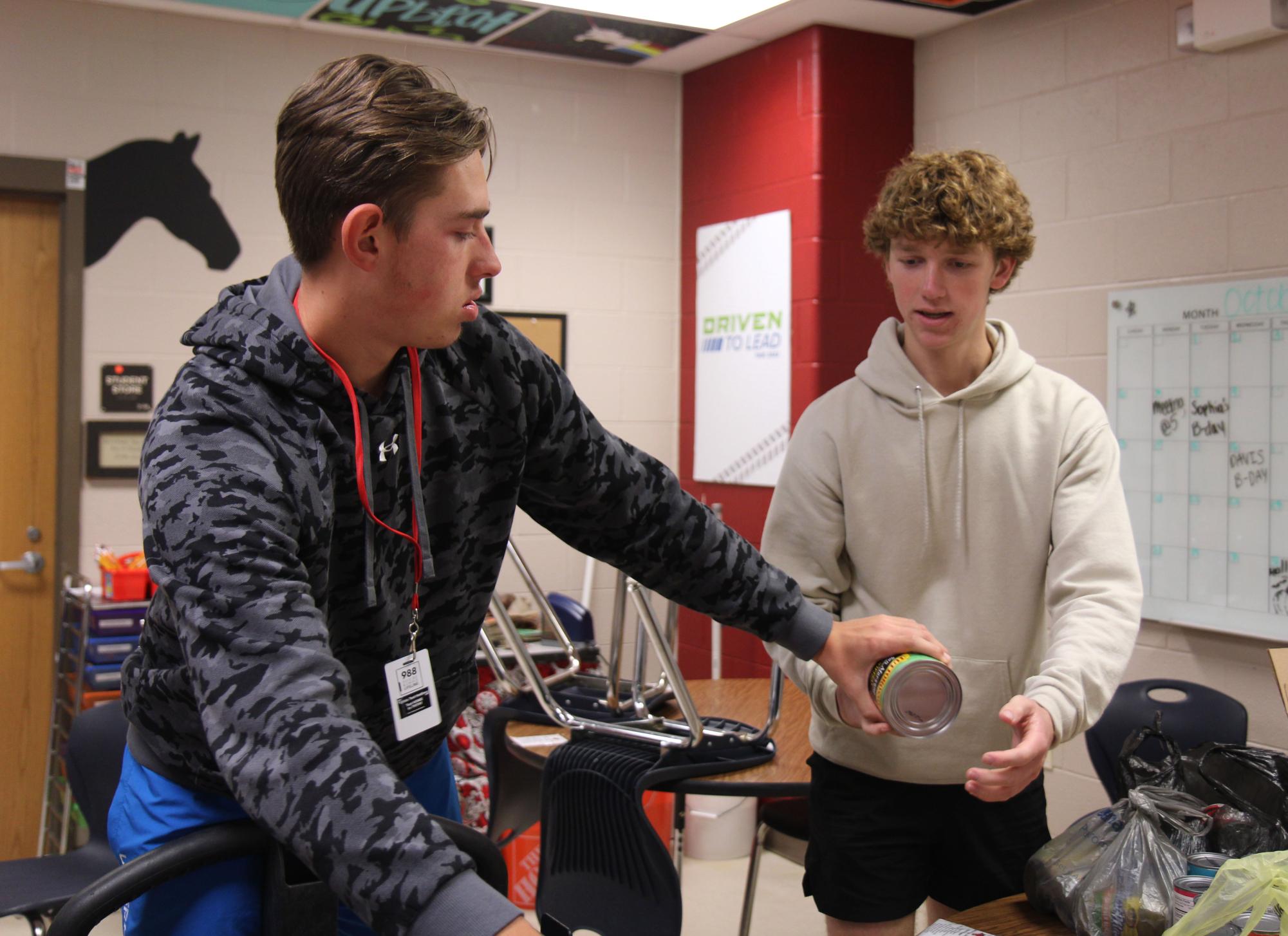 Jaxson Latimer and Davis Collier, 12, count cans for Can the Kitties, a food drive competition against Mansfield High School.