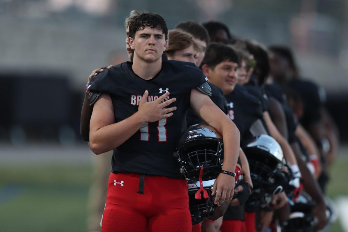 Whilst the national anthem plays, Alexander Walker, 12, lines up with his teammates to show respect to the American troops during the Homecoming game.