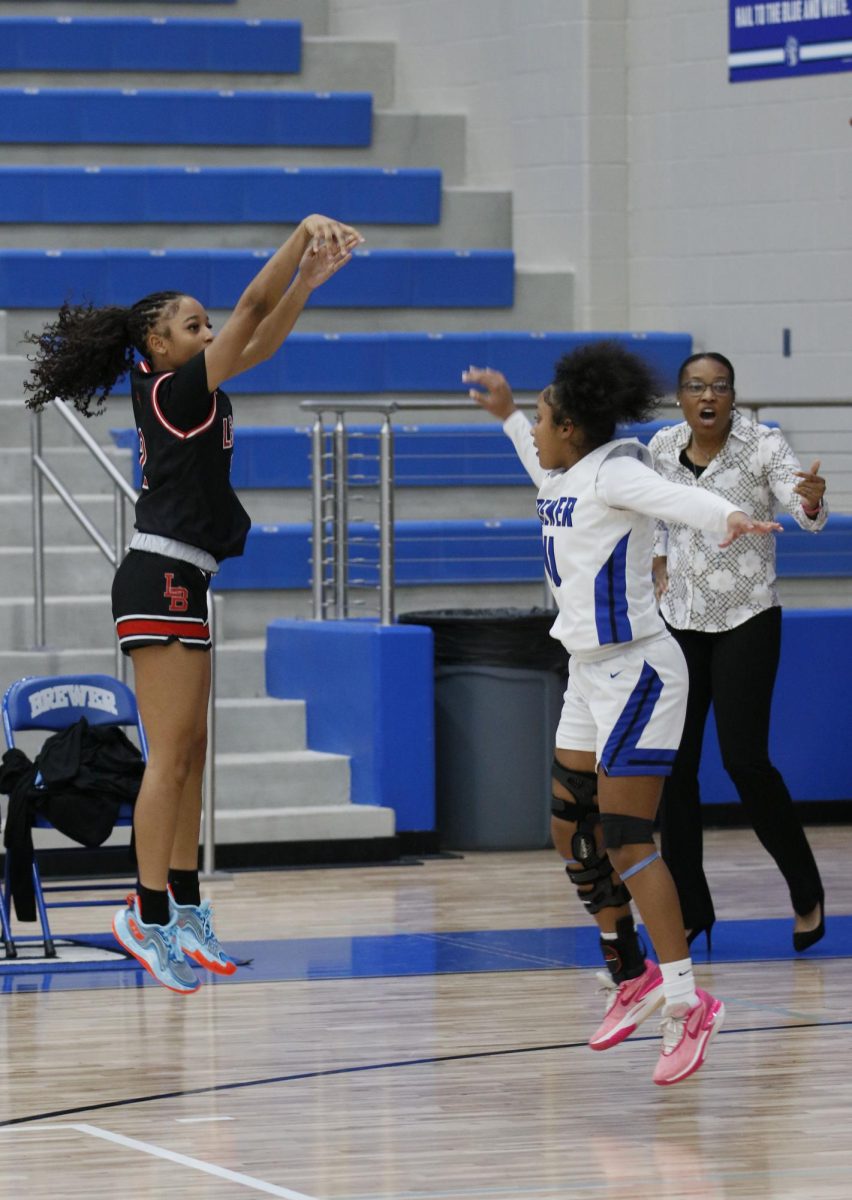 Madison Crawford, 11, shoots a three pointer while being contested by Brewers guard and makes it changing the score to 38-27.
