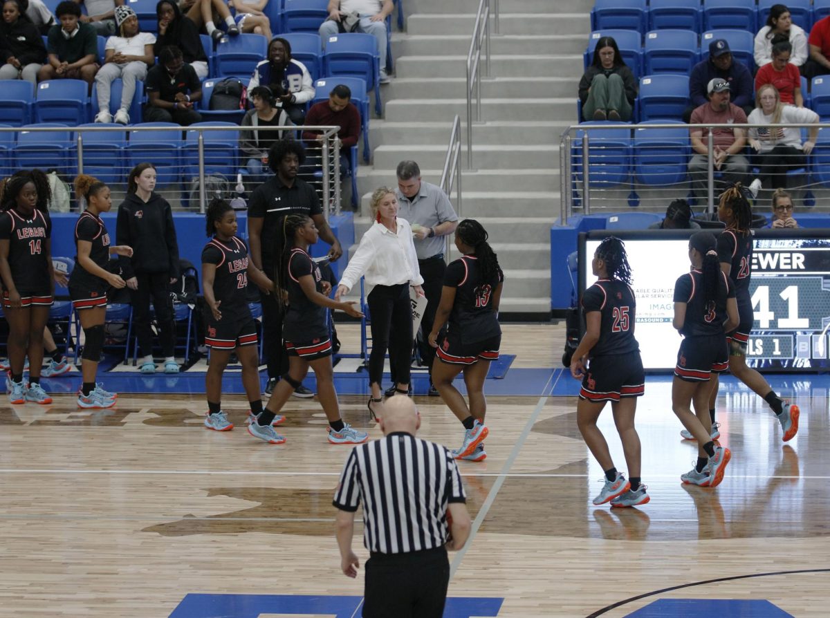 Coach Michelle Morris leads the Girls Varsity Basketball walking off the court for their last timeout before winning their first game of the season, with an ending score of 54-47.
