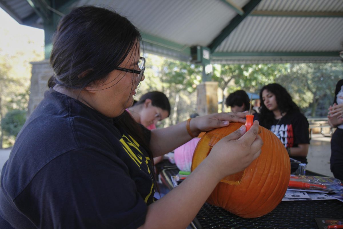 LDU’s club president, Maria Limas, 12, figures out where to carve out the eyes for her pumpkin.