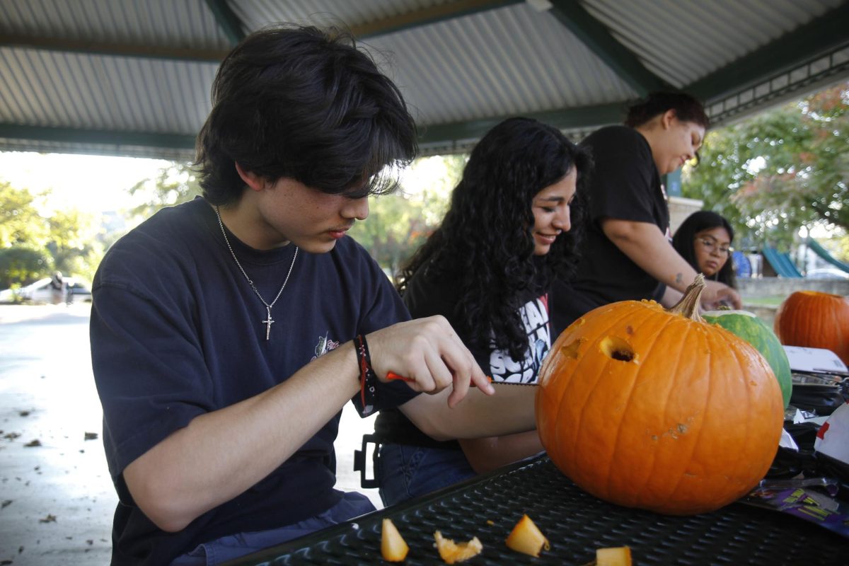 Christian Tran, 12, carves out a mouth for his pumpkin.