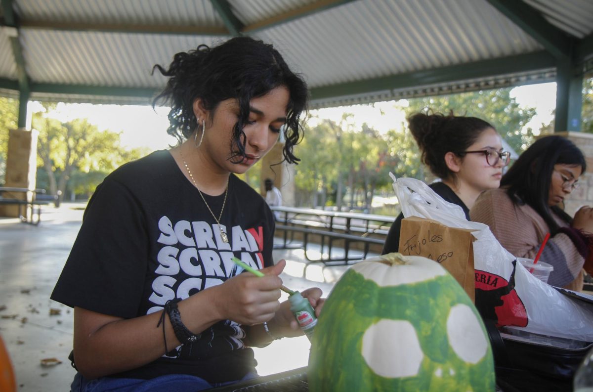 Jacquelin Sanches, 12, dips her brush into the paint to give her craft a more green look. LDU officer Sanches created a zombie pumpkin for her Halloween decoration. "Overall this event let me see how everyone's creative mind is," Sanches said.