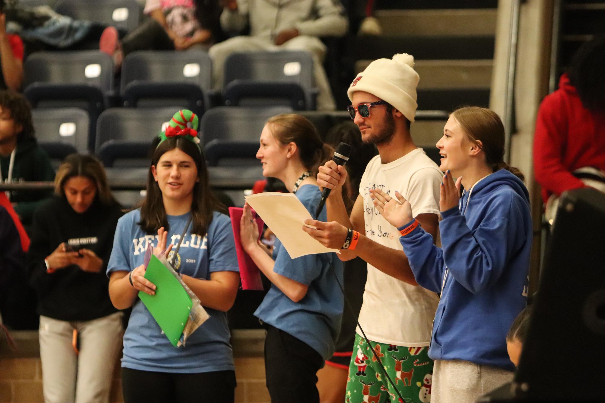 Key Club members, Rainer Cheek, 12, Sarah Marsteller, 12, Brynley Buck, 11, and Julianne Rouse, 11, announce the plays to students and faculty basketball game. 
