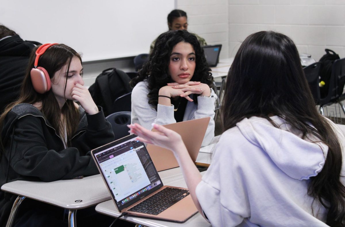 Sophomores Tala Abdulrazeq and Izabelle Guerra talk during debate club.