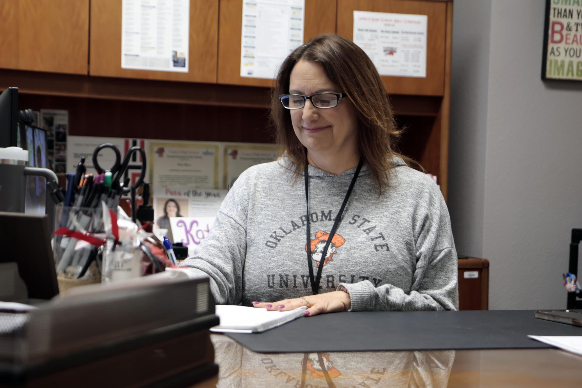 Ms. Katie Nance works at her desk on April 3. She works behind the scenes as Principal Stephanie Bonneau's secretary, organizing her meetings, taking phone calls and sending passes. 