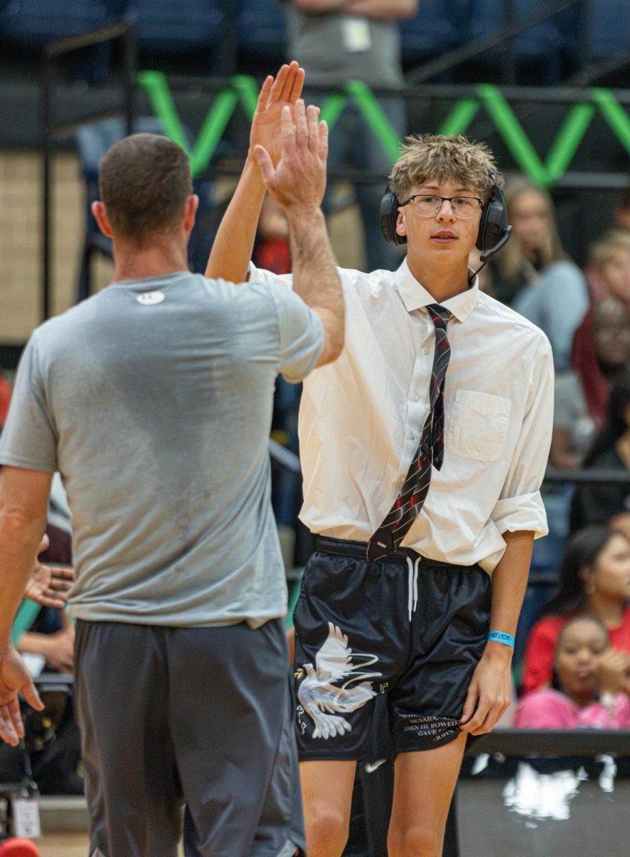 Sportsmanship:
As soon as a timeout was called, coach Doug Danser goes to high five student coach Jackson Graves, 12.