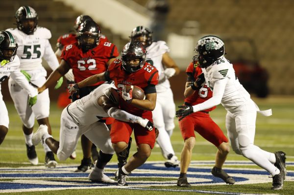 On senior night against Lake Ridge, Oct. 31, Harrison Jr. runs the ball upfield towards Lake Ridge players.