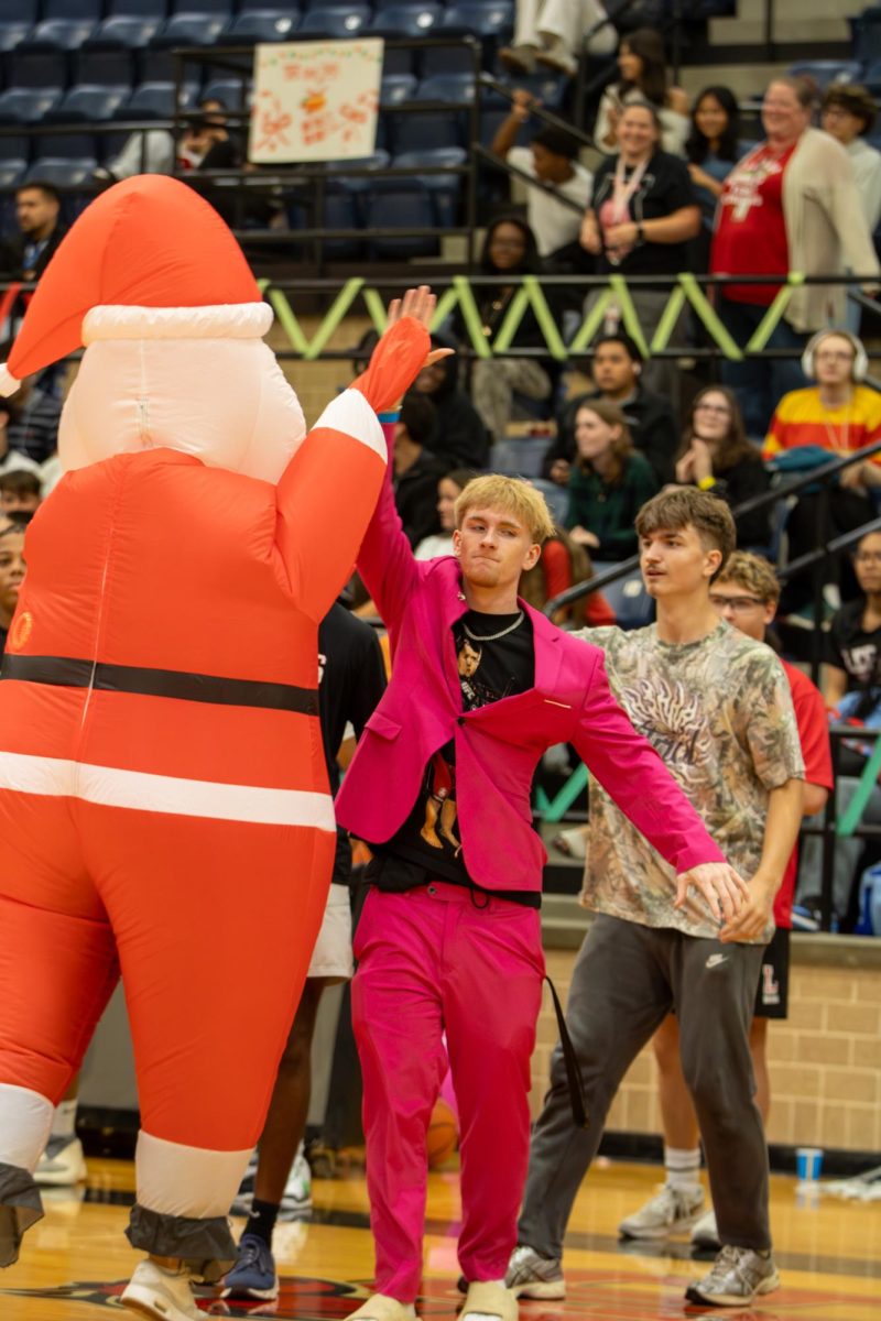 Celebration:
AP Stephine Monajami celebrates winning the teacher blow up race during the 4th quarter break with coach Kash Wilson, 12.