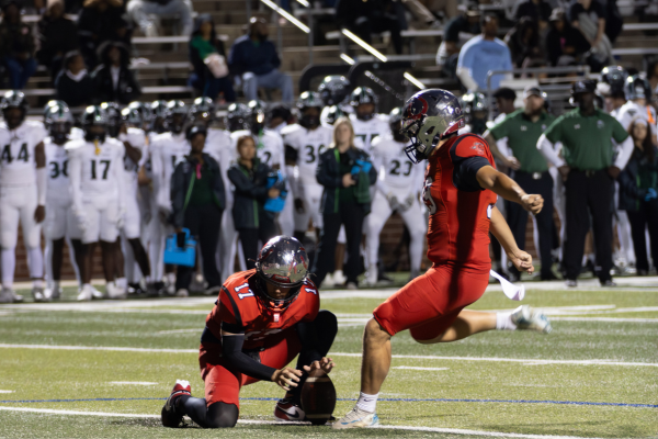 After the touchdown, senior Jeffrey Brown holds the ball in preparation for the kick from Jeremiah Kieffer, 12. Legacy lost 56-21 to Lake Ridge.
